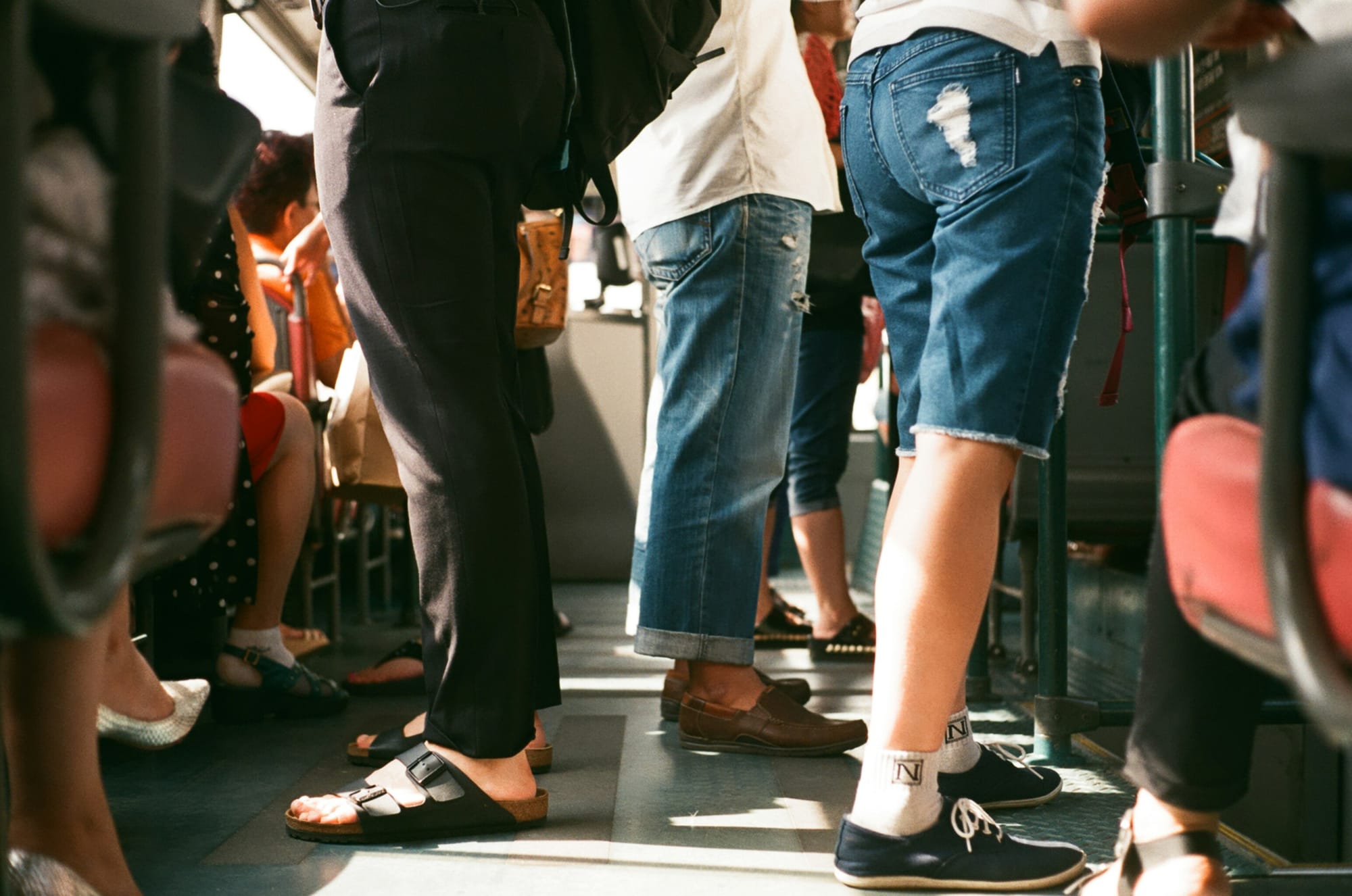 The legs of people on a bus