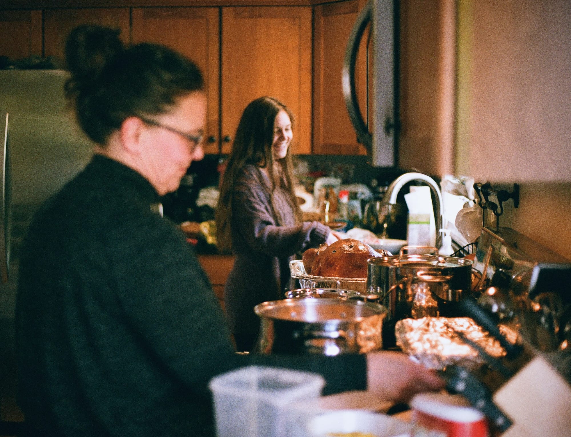 Two people making dinner in a kitchen, looking happy
